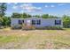 Charming single-story home features a well-maintained lawn and a welcoming front entrance with a wooden porch and stairs at 25126 Huston St, Brooksville, FL 34601
