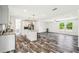 Modern open-plan kitchen with center island, stainless appliances and dark wood-look flooring at 25126 Huston St, Brooksville, FL 34601