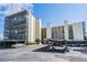A multi-story condo building with covered parking and mature landscaping on a clear, sunny day at 2617 Cove Cay Dr # 401, Clearwater, FL 33760
