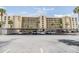 Exterior shot of a mid-rise condo building with covered parking and palm trees at 2617 Cove Cay Dr # 401, Clearwater, FL 33760