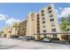 Multi-story condo building featuring balconies, covered parking, and lush palm trees at 2617 Cove Cay Dr # 401, Clearwater, FL 33760