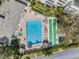 Aerial view of a community pool and shuffleboard court with lounge chairs and blue water at 2617 Cove Cay Dr # 401, Clearwater, FL 33760