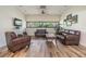 Cozy living room with leather sofas, wood floors, a ceiling fan, and large windows with natural light at 2617 Cove Cay Dr # 401, Clearwater, FL 33760