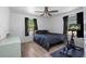 Bedroom with black bedding, ceiling fan, an exercise bike, and wood-look floors at 267 Broad St, Brooksville, FL 34604