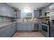 Well-appointed kitchen showcasing gray cabinetry, a modern backsplash, and stainless-steel appliances at 267 Broad St, Brooksville, FL 34604