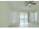 Open living room featuring neutral walls, tile flooring, and sliding glass doors to lanai at 29436 Zeller Ave, San Antonio, FL 33576