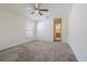 The main bedroom features carpet flooring, a ceiling fan, and a view of the en-suite bathroom at 29436 Zeller Ave, San Antonio, FL 33576