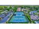 Aerial view of tennis courts with surrounding neighborhood homes in residential area at 2961 Briar Cliff Dr, Palm Harbor, FL 34684