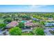 Aerial view of the community center with a swimming pool, tennis courts, golf course and lush greenery at 2961 Briar Cliff Dr, Palm Harbor, FL 34684
