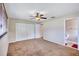 Bedroom featuring neutral walls, brown carpet, ceiling fan, closet, and ensuite access to a bathroom at 2961 Briar Cliff Dr, Palm Harbor, FL 34684