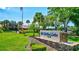Community sign with lush landscaping and palm trees in front of the community center at 2961 Briar Cliff Dr, Palm Harbor, FL 34684