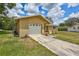 Single-story home with a front-facing garage, and a inviting front porch area at 2961 Briar Cliff Dr, Palm Harbor, FL 34684