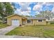 Charming single-story home with a well-maintained lawn, attached garage, and inviting front entrance at 2961 Briar Cliff Dr, Palm Harbor, FL 34684