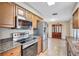 Stylish kitchen featuring stainless steel appliances and granite countertops with a view to the dining area at 2961 Briar Cliff Dr, Palm Harbor, FL 34684