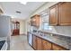 Updated kitchen with stainless steel appliances, wooden cabinetry, and granite countertops at 2961 Briar Cliff Dr, Palm Harbor, FL 34684