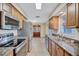 Kitchen with modern appliances, granite counters, tile flooring, and view into dining area at 2961 Briar Cliff Dr, Palm Harbor, FL 34684