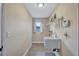 Neutral laundry room features a wash basin, shelving, security system pad and a window at 2961 Briar Cliff Dr, Palm Harbor, FL 34684
