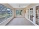 Bright sunroom featuring neutral walls, carpet, a ceiling fan, and natural light from large windows at 2961 Briar Cliff Dr, Palm Harbor, FL 34684