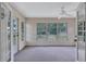 Bright sunroom featuring neutral walls, carpet, a ceiling fan, and natural light from large windows at 2961 Briar Cliff Dr, Palm Harbor, FL 34684