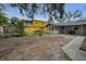 A large backyard ideal for entertaining or relaxing, with a neighboring vibrant yellow house at 306 S Highland Ave, Clearwater, FL 33755