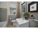 Bathroom featuring a white sink, toilet, bathtub with curtain, and enhanced with modern wall decor at 306 S Highland Ave, Clearwater, FL 33755