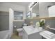 Well-lit bathroom with a white sink, toilet, bathtub with curtain, and grey tiling with yellow accents at 306 S Highland Ave, Clearwater, FL 33755