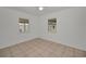 Cozy bedroom featuring tile flooring and natural light from two windows with outdoor views at 306 S Highland Ave, Clearwater, FL 33755