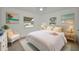 Bright bedroom featuring a white bed with textured bedding, tile floors, and beach themed artwork at 306 S Highland Ave, Clearwater, FL 33755