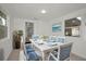 Bright dining room with seating for six, features tile floors, white table and beach scene artwork at 306 S Highland Ave, Clearwater, FL 33755