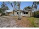 Single-story home with an American flag is set amongst mature trees in a tranquil setting at 306 S Highland Ave, Clearwater, FL 33755