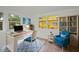 Inviting home office featuring a bright blue accent chair and desk with natural light and hardwood floors at 306 S Highland Ave, Clearwater, FL 33755