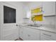 Bright kitchen showcases white cabinetry, a stainless steel sink and natural lighting from the window at 306 S Highland Ave, Clearwater, FL 33755