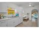 Bright eat-in kitchen features white cabinets, marble counters, stainless steel sink and adjacent dining area at 306 S Highland Ave, Clearwater, FL 33755