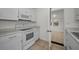 Updated kitchen showcasing white cabinets, tile flooring, and a view to a separate bonus room at 306 S Highland Ave, Clearwater, FL 33755