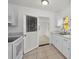 Bright kitchen featuring tile floor, white cabinetry, and a view into a separate room at 306 S Highland Ave, Clearwater, FL 33755