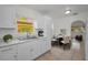 Bright kitchen features white cabinets, marble counters, stainless steel sink and breakfast nook with round table at 306 S Highland Ave, Clearwater, FL 33755