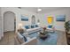 Bright living room with neutral furniture, blue accents, and tiled floors offers a comfortable gathering space at 306 S Highland Ave, Clearwater, FL 33755