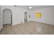 Bright, open living room with tile flooring, ceiling fan, and arched doorways at 306 S Highland Ave, Clearwater, FL 33755