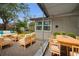 Exterior patio featuring light wood furniture, a dining table set, and trimmed shrubs for added privacy at 306 S Highland Ave, Clearwater, FL 33755