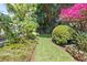 Lush backyard with a manicured lawn and vibrant tropical landscaping creating a serene outdoor space at 3501 S Drexel Ave, Tampa, FL 33629