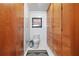 Bathroom features built-in cabinets, a toilet, tiled floor and walls, and wood accent walls at 3501 S Drexel Ave, Tampa, FL 33629