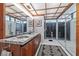 Bathroom features a double vessel sink, shower and a view of tropical plants, tiled floors and walls, and coffered ceiling at 3501 S Drexel Ave, Tampa, FL 33629