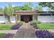 Mid-century modern home with manicured front yard, featuring walkway and tasteful landscaping at 3501 S Drexel Ave, Tampa, FL 33629