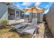 Backyard area showcasing outdoor lounge seating, patio, shade umbrella, shed, and mature landscaping at 3540 Cockatoo Dr, New Port Richey, FL 34652