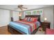 Bedroom featuring a ceiling fan, wood flooring, and a brightly patterned bedspread at 3540 Cockatoo Dr, New Port Richey, FL 34652