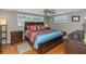 Comfortable bedroom featuring a ceiling fan, wood flooring, and a brightly patterned bedspread at 3540 Cockatoo Dr, New Port Richey, FL 34652