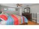 Comfortable bedroom featuring a ceiling fan, wood flooring, and a brightly patterned bedspread at 3540 Cockatoo Dr, New Port Richey, FL 34652