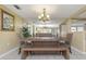 Inviting dining area with a rustic wooden table, bench seating, and a contemporary chandelier, perfect for Gathering gatherings at 3540 Cockatoo Dr, New Port Richey, FL 34652