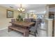 Inviting dining area with a rustic wooden table, bench seating, and a contemporary chandelier, perfect for Gathering gatherings at 3540 Cockatoo Dr, New Port Richey, FL 34652