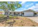 Charming single-story home with a two-car garage features a well-manicured lawn and a large tree at 3540 Cockatoo Dr, New Port Richey, FL 34652